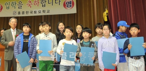 <김진만 한인회 고문(왼쪽)으로부터 장학금을 받은 초등부 학생들 >